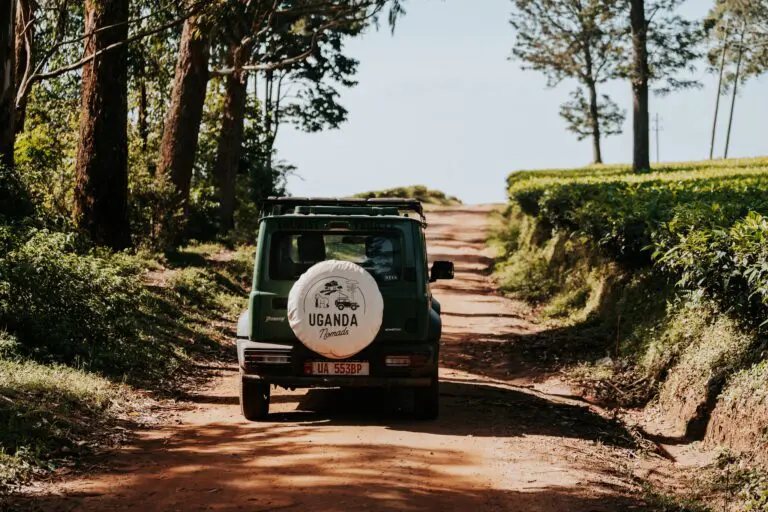 green safari jeep on dirt road in Uganda