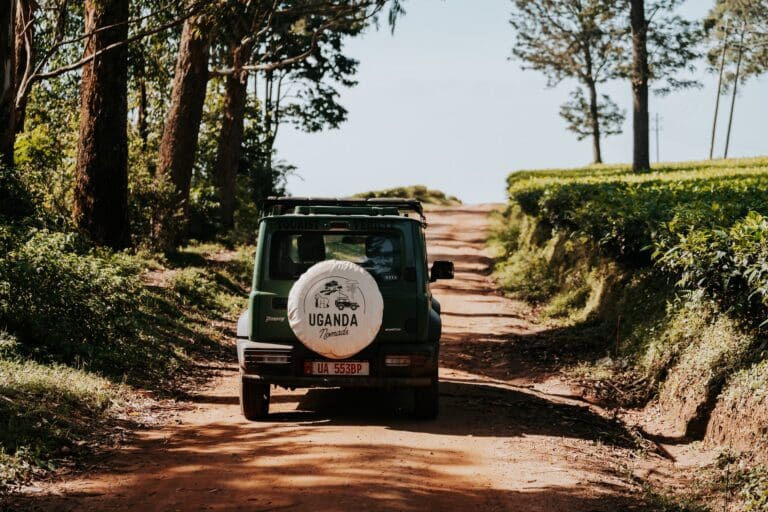 green safari jeep on dirt road in Uganda